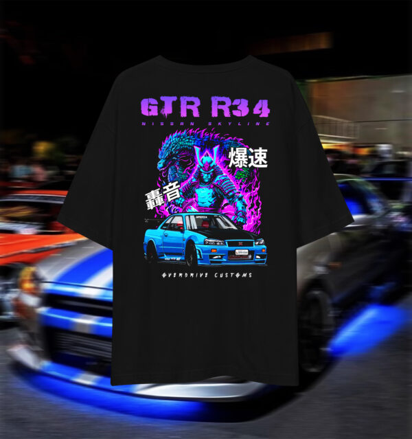 Oversized drop-shoulder graphic T-shirt featuring the Nissan Skyline GTR R34 “Godzilla,” JDM streetwear by Overdrive Customs for car enthusiasts.